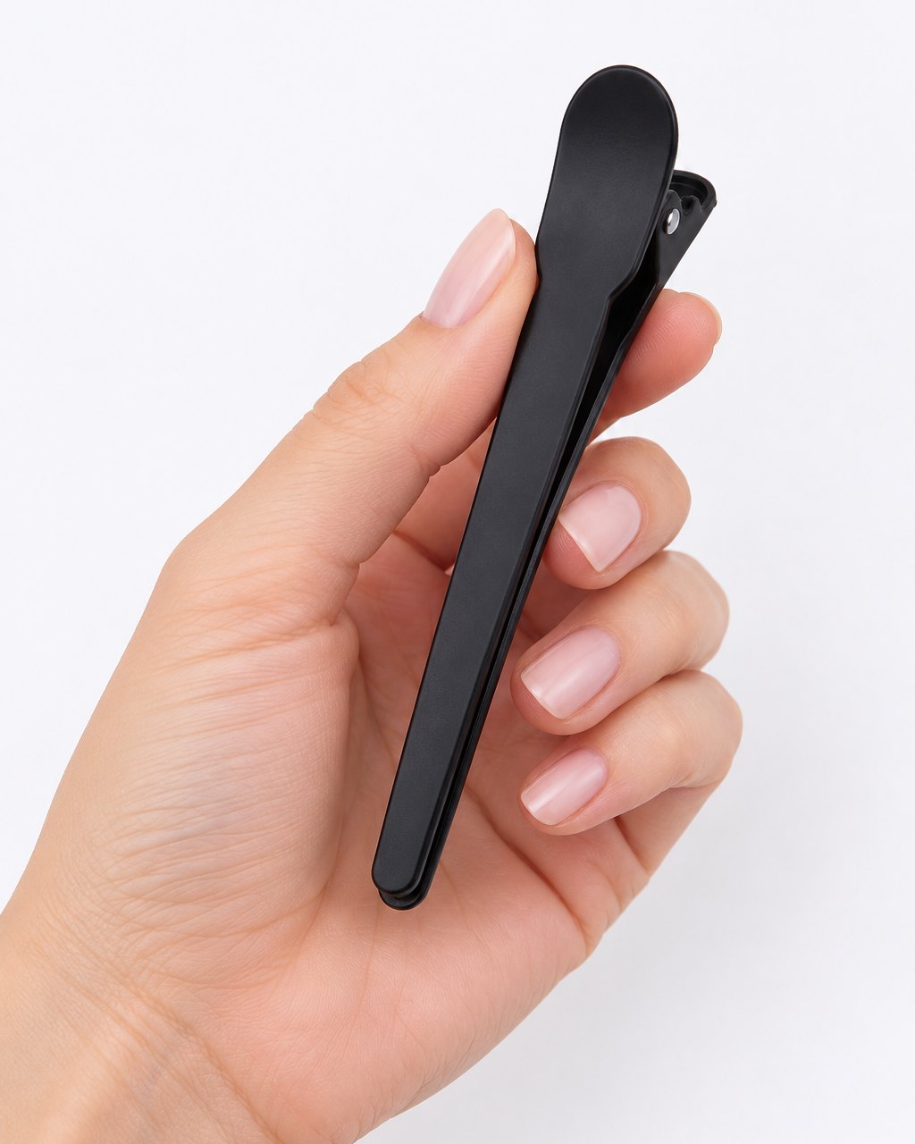One black clip held between finger and thumb
