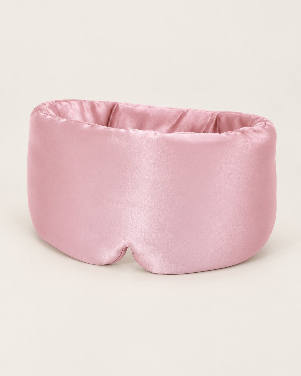 Pink wide wraparound satin sleep mask on a light background