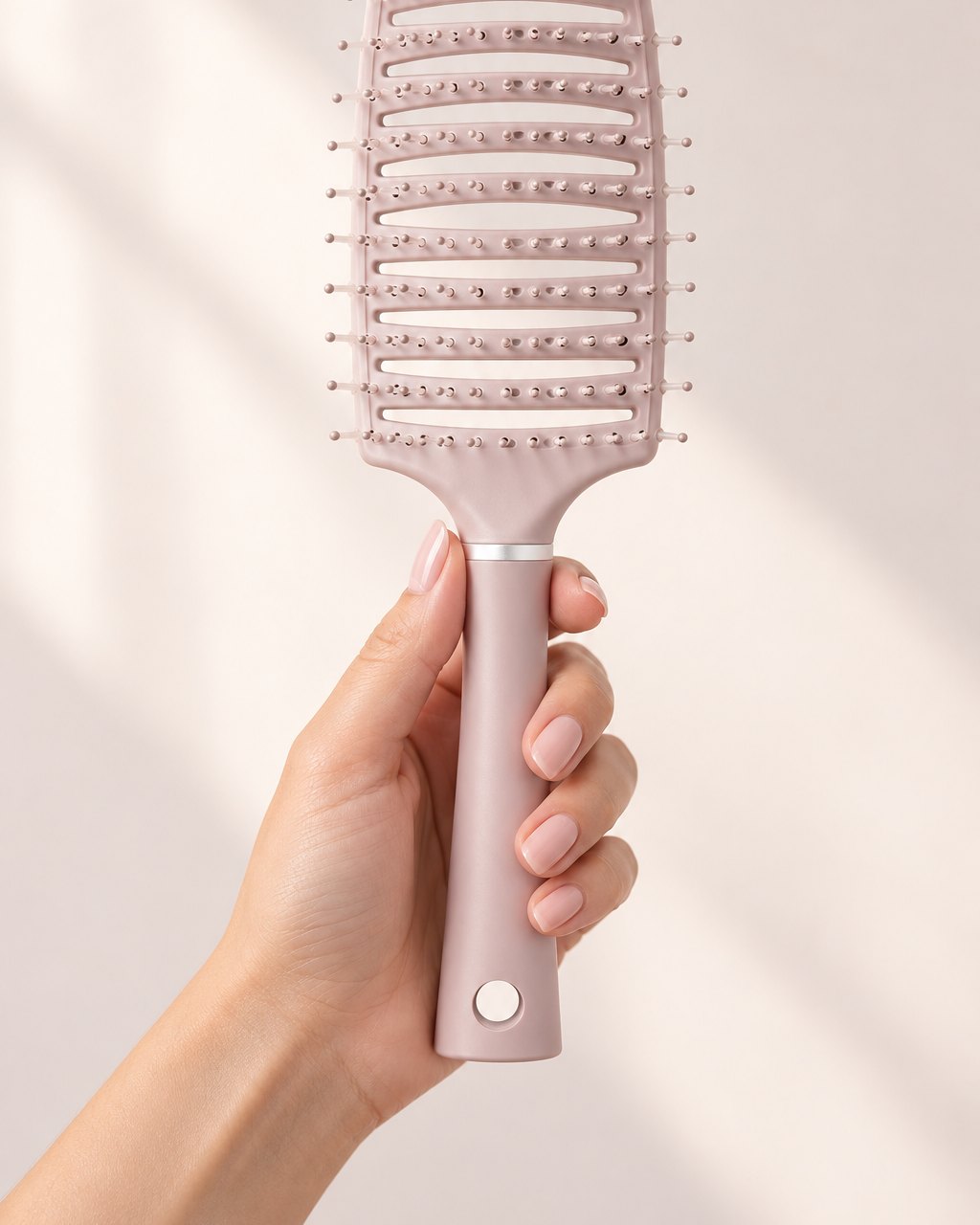 The vented brush held in one hand, a full-size paddle