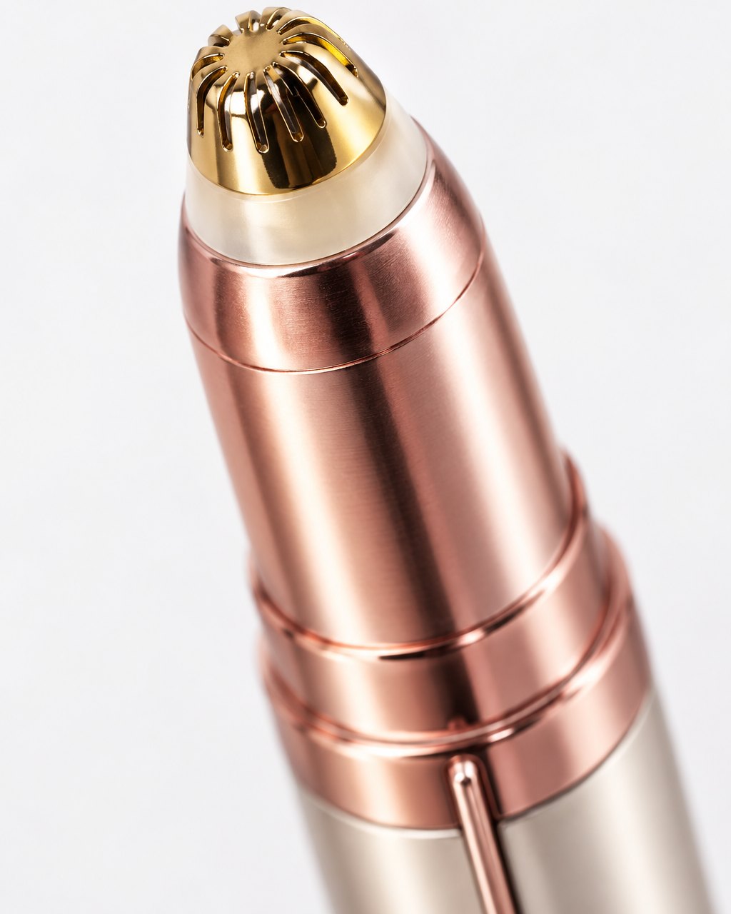 Close-up of the trimmer's rounded gold-tone head with its slotted guard