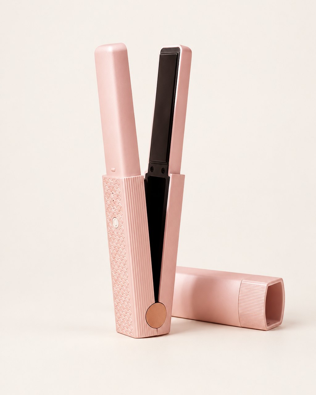 Pink cordless mini flat iron standing open beside its cap on a light background