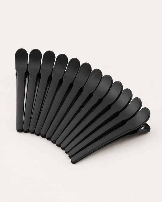 Twelve matte black duckbill sectioning clips fanned out on a light background