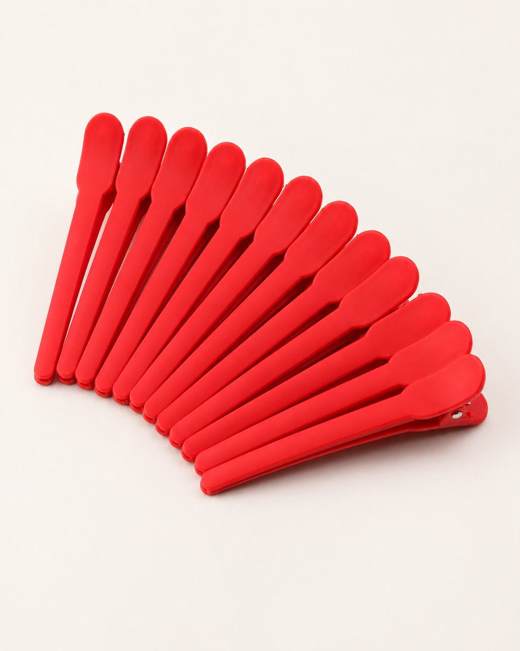 Twelve matte red duckbill sectioning clips fanned out