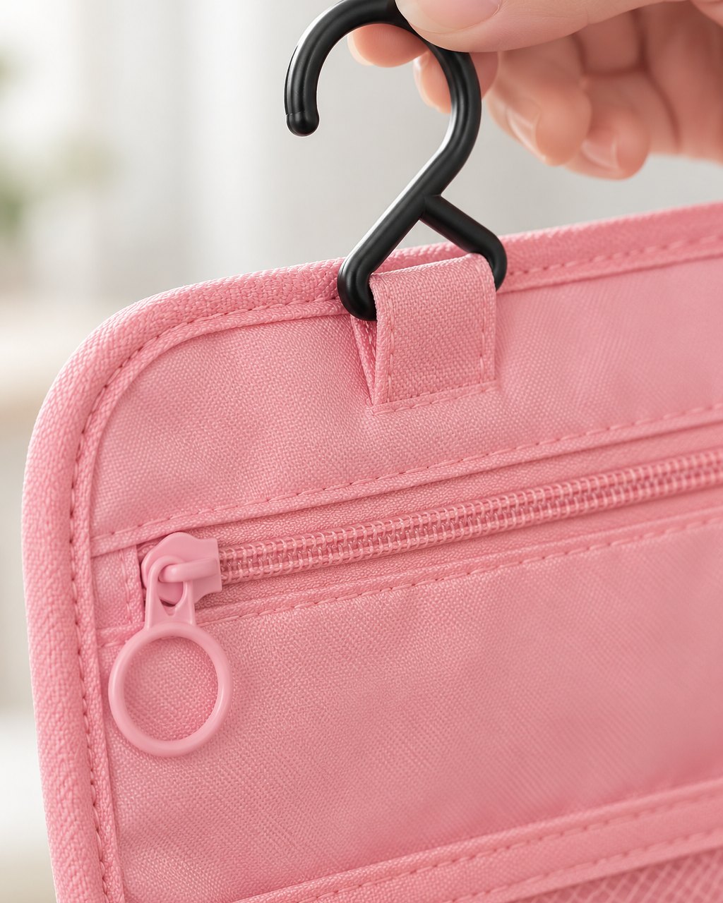 Close-up of the fold-out hook and zip on the toiletry bag