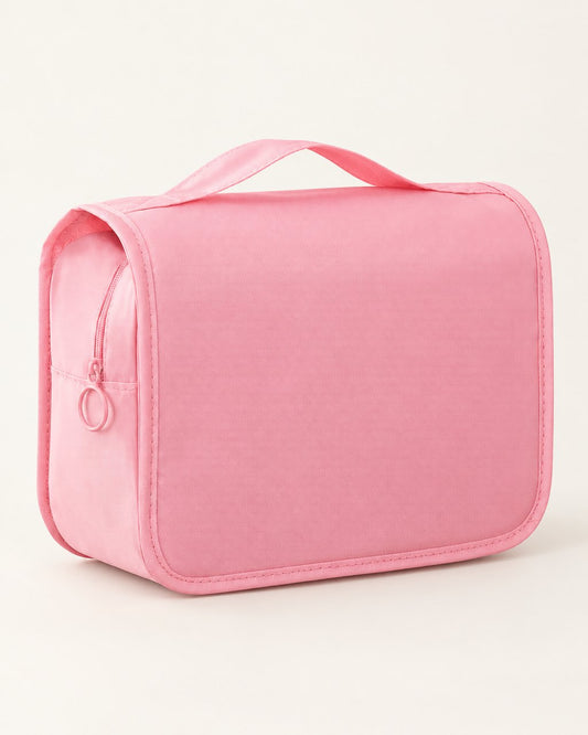 Pink hanging toiletry bag with a top handle on a light background