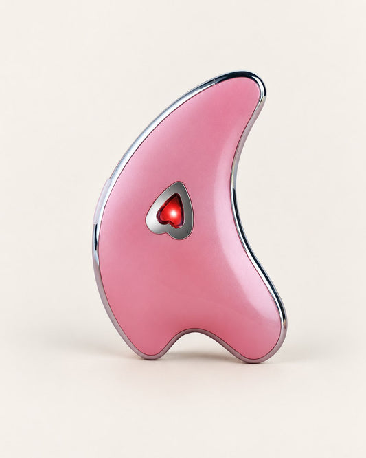 Pink dolphin-shaped gua sha with a heart light in the middle, on a light background