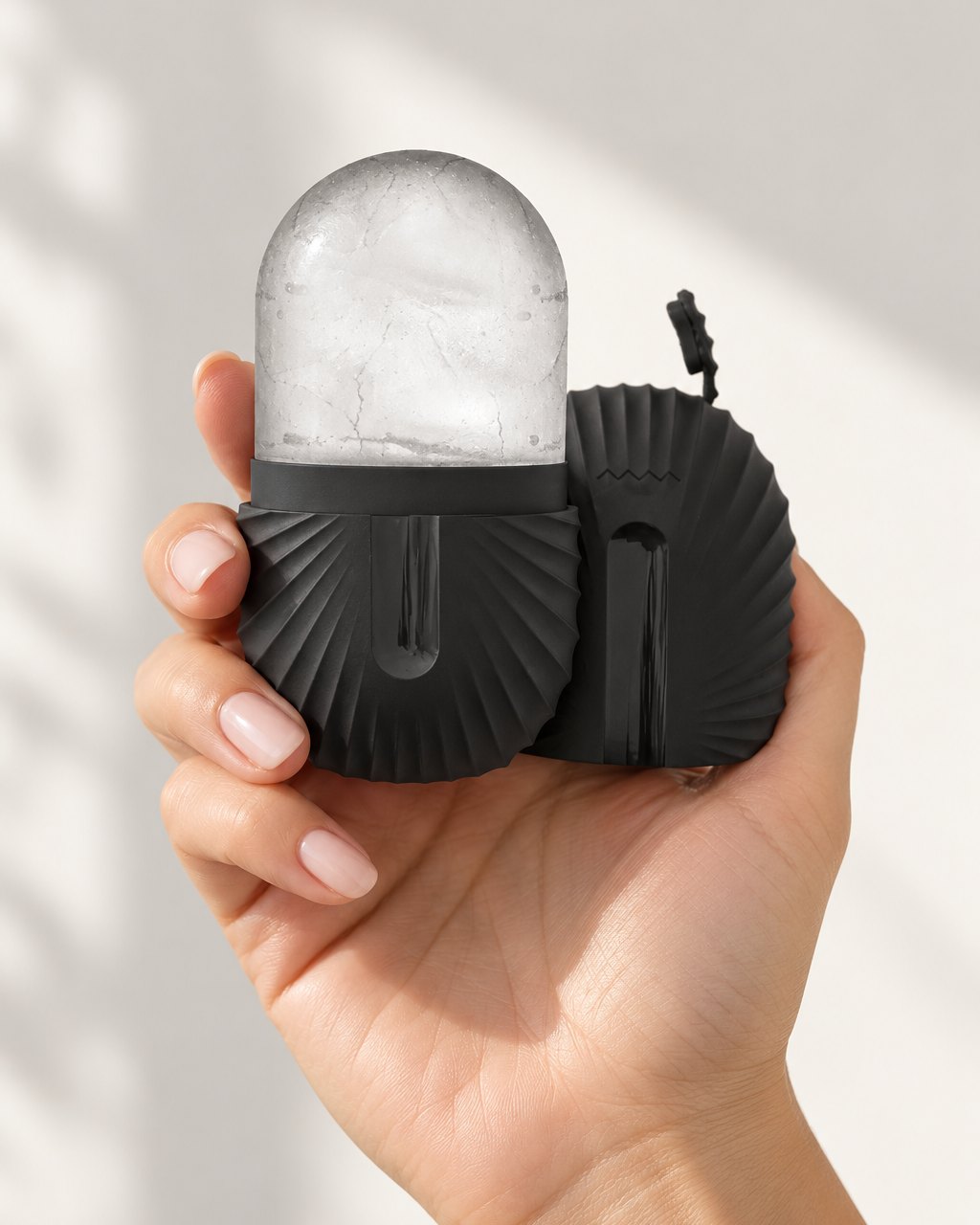 The ice capsule held in one hand by its ribbed base