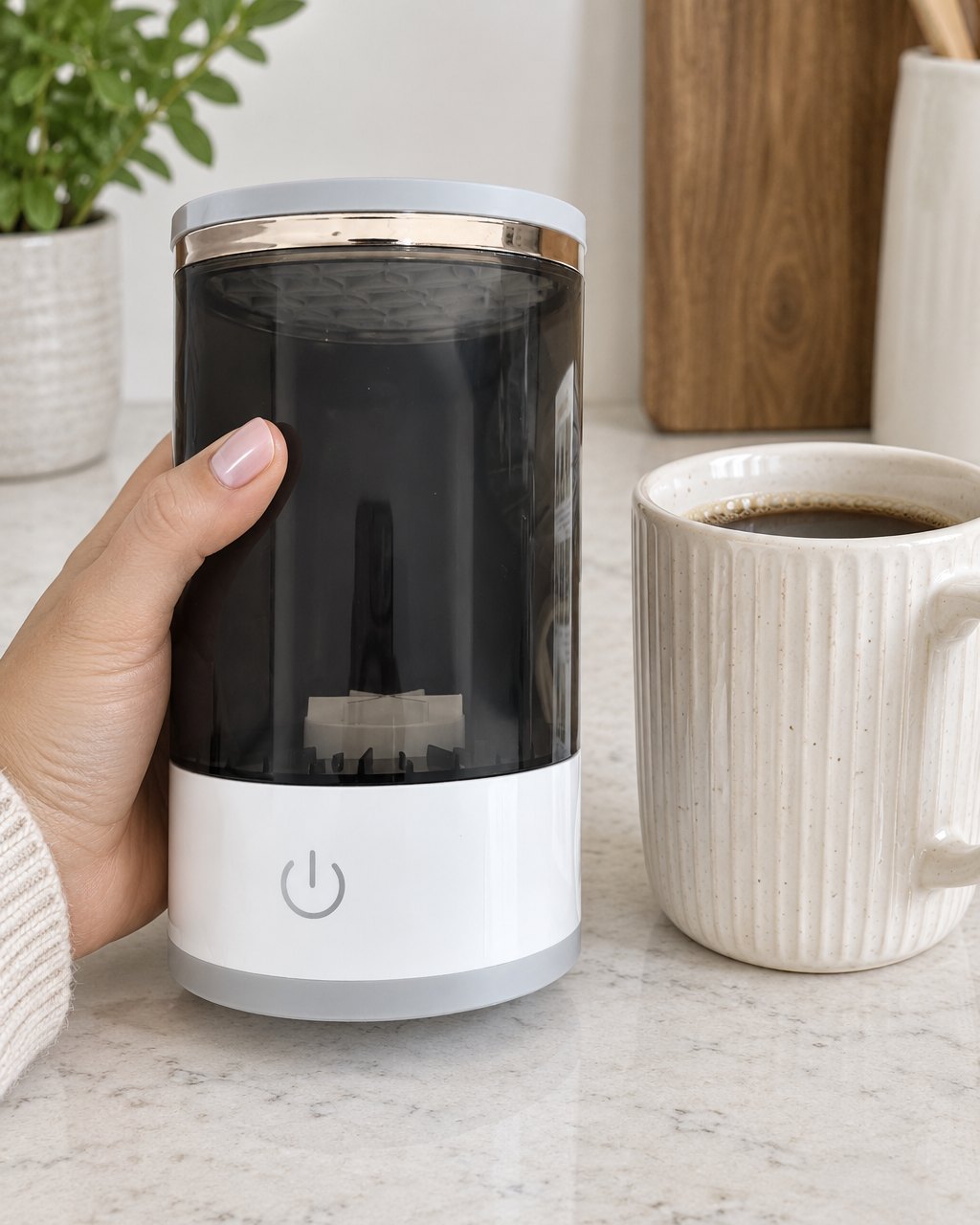 The brush cleaner held in one hand, about the height of a tall mug
