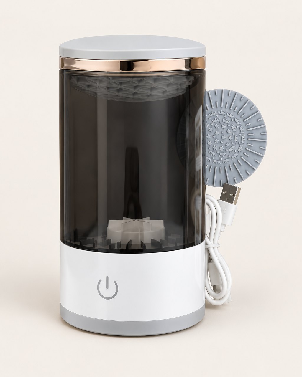 Electric makeup brush cleaner with a smoke tinted jar and white base on a light background