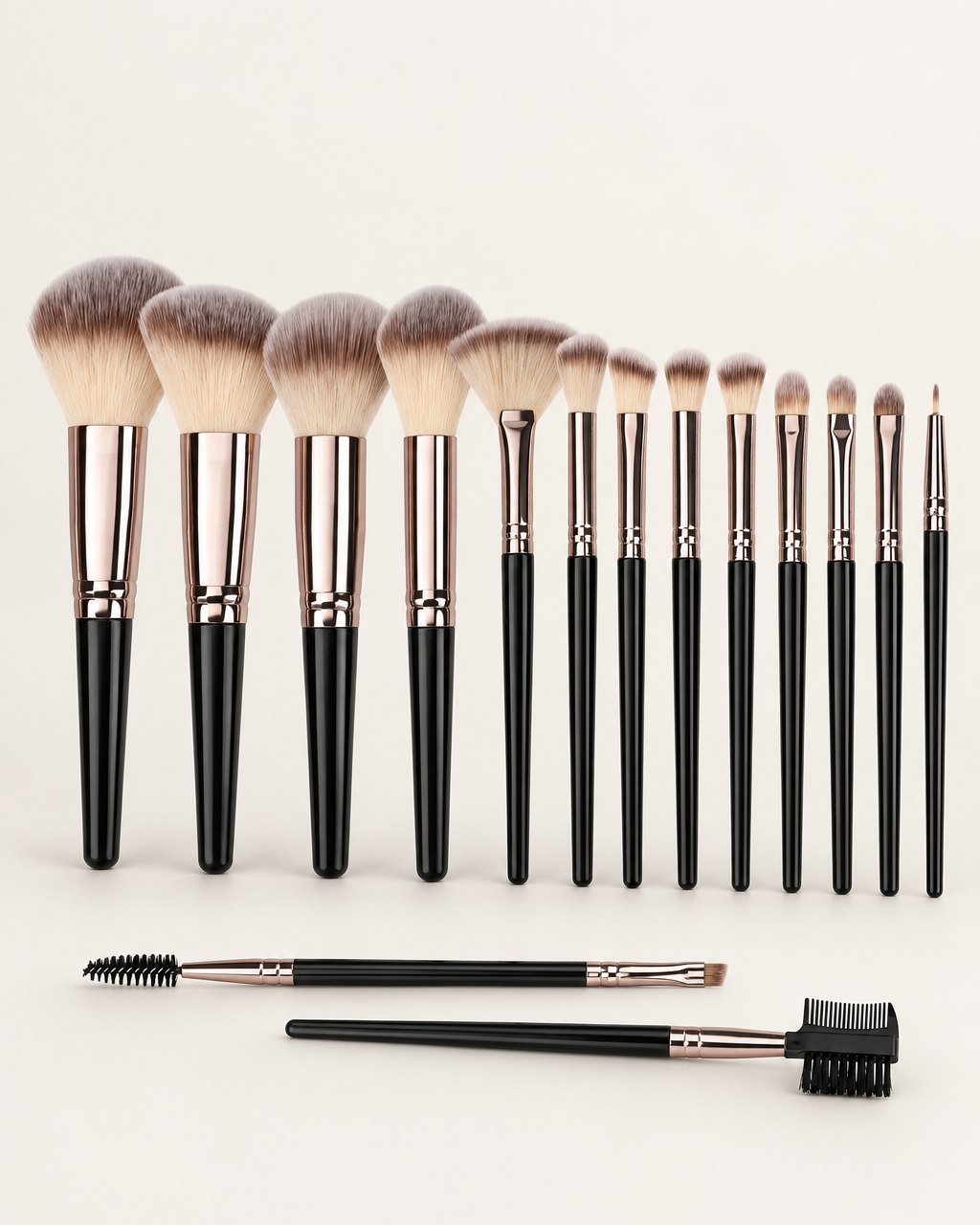 Fifteen black-handled makeup brushes with rose-gold ferrules lined up on a light background