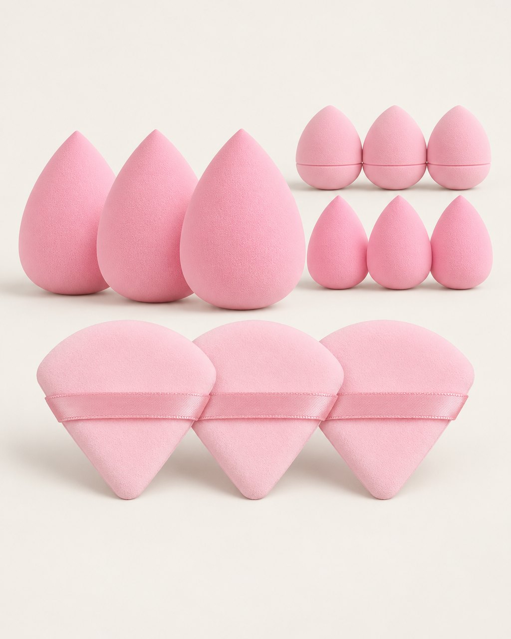 Pink set of twelve makeup sponges and triangle powder puffs laid out on a light background