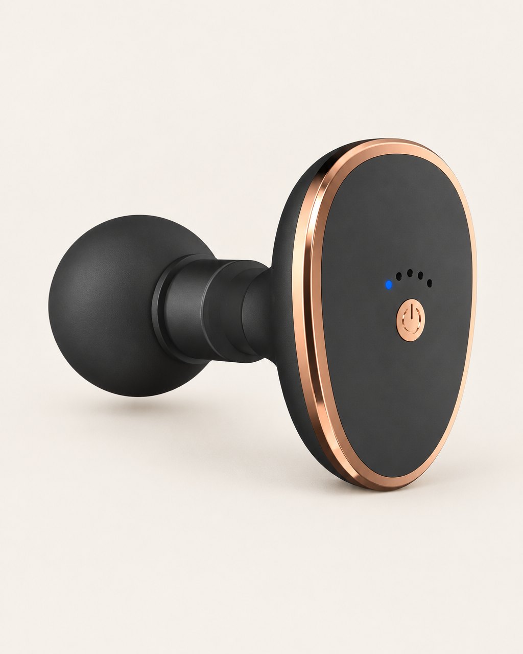 Black mini massage gun with a round head and rose-gold-tone trim on a light background
