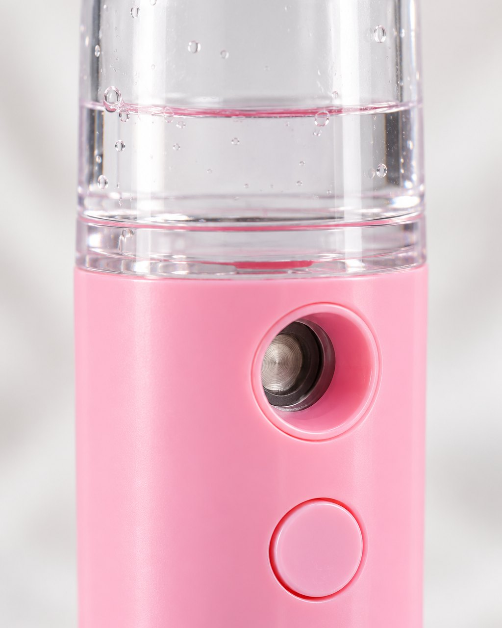 Close-up of the mister's spray window, button and clear tank