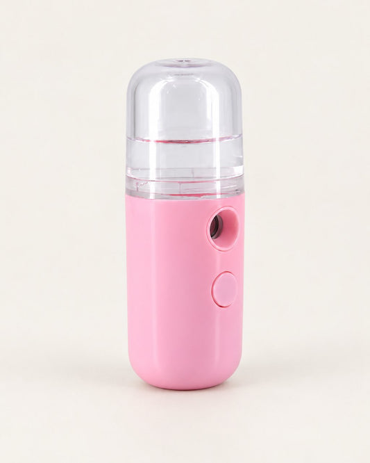 Pink pocket nano facial mister with a clear tank on a light background