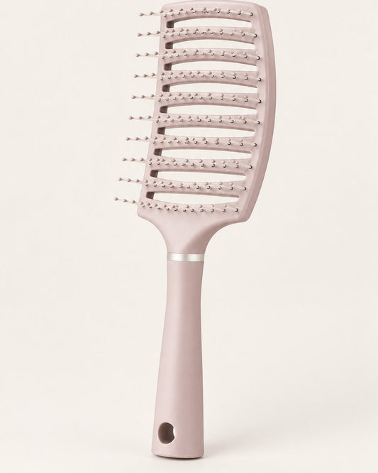 Pink curved vented detangling brush on a light background